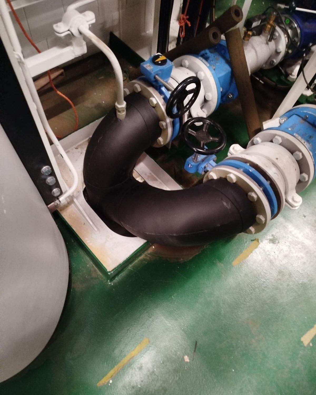 Black elastomeric foam insulation on pipe bends in a machinery space